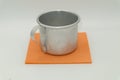 A simple aluminum mug on an orange napkin. Handle on the left. Royalty Free Stock Photo