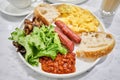 Simple American style Breakfast with sausages, scrambled eggs, baked beans, mushrooms and tomatoes. This dish is full of Royalty Free Stock Photo