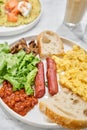 Simple American style Breakfast with sausages, scrambled eggs, baked beans, mushrooms and tomatoes. This dish is full of Royalty Free Stock Photo