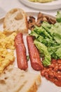 Simple American style Breakfast with sausages, scrambled eggs, baked beans, mushrooms and tomatoes. This dish is full of Royalty Free Stock Photo