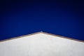 Simple background of a white triangular roof and clean blue sky, free space for text Royalty Free Stock Photo