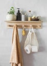 A simple bathroom interior - a wooden shelf with a towel, shampoo, a flower. Minimalism style Royalty Free Stock Photo