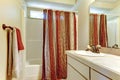 Simple bathroom with red and brown colors in shower curtain and