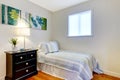 Simple bedroom with black nightstand and painting.