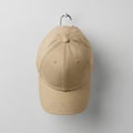 Simple beige baseball cap hanging on a gray background Royalty Free Stock Photo