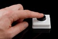 A simple black button presses a finger