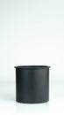 A simple black empty container like vase kept on vertical isolated white background