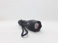 A simple black flashlight with rechargeable battery on white isolation background