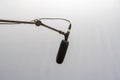 Simple black studio mic, directional microphone hanging placed on a mic stand, audio voice recording studio podcasting, live show