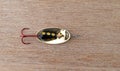 Simple black and yellow spoon fishing lure with a red treble hook