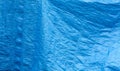 Simple blue plastic tarp, woven crumpled plain used protective industrial tilt curtain abstract background texture, object closeup Royalty Free Stock Photo