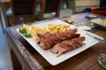 Simple breakfast consisting of fried sausages, french fries and a little cabbage salad on a white plate Royalty Free Stock Photo