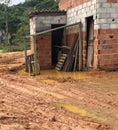 simple brick house with old wood around it in a land full of mud and puddles of water