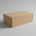 A simple brown cardboard box sits on a plain gray surface ready for shipping or storage Royalty Free Stock Photo