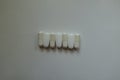 Simple capsules of magnesium citrate and caplets of calcium citrate in a row from above