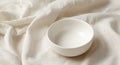 Simple Ceramic Bowl on Draped Fabric, a Study in Whites and Subtle Textures. Royalty Free Stock Photo