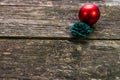 Simple Christmas decoration, red bubble and green painted pine cone on aged weathered pine wood boards Royalty Free Stock Photo