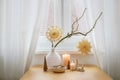 Simple Christmas decoration with two paper stars hanging on bare branches, candles and small natural objects on a table by the Royalty Free Stock Photo
