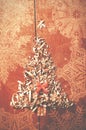 Simple Christmas tree arranged from sawdust, wood-chips on wooden background. Orange cute ribbon. Royalty Free Stock Photo