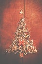 Simple Christmas tree arranged from sawdust, wood-chips on wooden background. Orange cute ribbon. Royalty Free Stock Photo