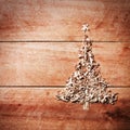 Simple Christmas tree arranged from sawdust, wood-chips on wooden background Royalty Free Stock Photo