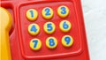 Simple colorful small telephone landline phone toy with little number keys, keypad closeup detail, nobody. Learning numbers, maths Royalty Free Stock Photo