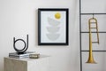 Cozy and stylish living room with mock up poster, white pouf, lamp, consola and personal accessories. Beige wall with carpet. Home