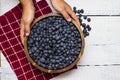 Hands holding a big, heaping wooden bowl full of ripe, juicy blueberries Royalty Free Stock Photo