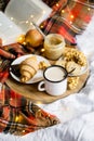 Simple country home breakfast in bed, coffee with milk and homemade pastry on plaid blanket Royalty Free Stock Photo