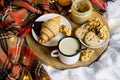 Simple country home breakfast in bed, coffee with milk and homemade pastry on plaid blanket Royalty Free Stock Photo