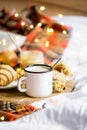 Simple country home breakfast in bed, coffee with milk and homemade pastry on plaid blanket Royalty Free Stock Photo