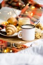 Simple country home breakfast in bed, coffee with milk and homemade pastry on plaid blanket Royalty Free Stock Photo