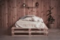 Simple cozy bed in wooden apartment. Front view. Comfortable place or space for rest