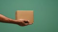 Simple Delivery Mockup: Hand Holding Brown Gift Box on Light Blue Background - Packaging and Parcel Concept Royalty Free Stock Photo