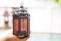 Simple design moroccan metal lamp in clay hand over blurred outdoor background Royalty Free Stock Photo