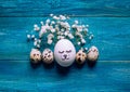 Simple DIY easter egg with drawn cute face surrounded with quial eggs