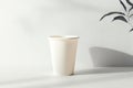A Simple, Elegant Beige Paper Cup Placed on an Unblemished White Background with Subtle Shadows Royalty Free Stock Photo