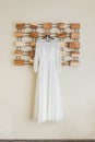 simple elegant bridesmaid dress weighs on a wooden hanger on the wall. Royalty Free Stock Photo