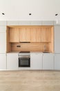 Simple empty modular kitchen area in modern apartment. Furniture minimalism with lots of cabinets, oven and stove for Royalty Free Stock Photo