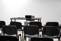 Simple empty prepared lecture hall, conference room chairs and presenter`s desk with a video projector, white screen, nobody