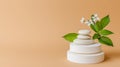 A simple and empty stone stack platform or podium, with a flower twig, displayed on a beige background. This minimal Royalty Free Stock Photo