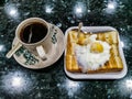 Simple English breakfast with fried eggs, toast and tea on black background