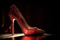 Simple expensive luxury pair of red high heels real detail stage spotlight.