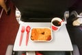 Simple in-flight meal of rice, meat, coffee in disposable utensils Royalty Free Stock Photo