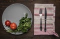 Simple food, tomatoes, parsley and penne pasta on a gray plate, lined on a wooden background, top vie