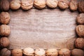 Simple frame arranged from walnuts on wooden background.