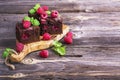 Simple fresh homemade brownies flavored with berries juicy ripe raspberry on wooden background decorated mint Royalty Free Stock Photo