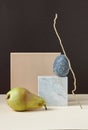 Simple geometric minimalism still life with mandarin on marble with natural zig-zag branch balance on beige table on brown backgro