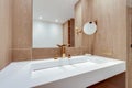 Simple golden tap in classic bathroom square washbasin with mirror and decorations wooden natural tones ecological