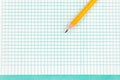 Simple graphite pencil on blank sheet of checkered notebook. School notebook with pencil on desktop Royalty Free Stock Photo